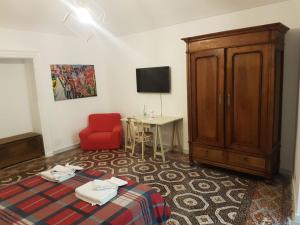 Zimmer mit einem Bett, einem Schrank und einem Tisch in der Unterkunft GusterHouse in Ivrea