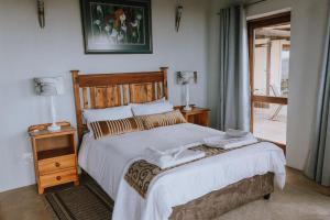 1 dormitorio con 1 cama con 2 toallas en Ocean View Cottage, Springerbaai en Boggomsbaai