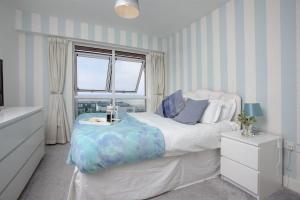 a bedroom with a large bed and a window at Fistral View, Pentire in Newquay