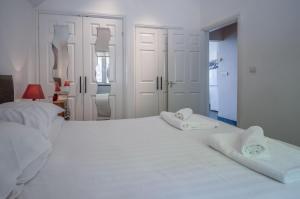 a white bedroom with two white towels on a bed at Manor View - 1 Bedroom Apartment - Pendine in Pendine