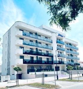 a white apartment building with blue balconies at Atmosphere by the Sea in Eforie Nord