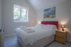 a bedroom with a white bed and a window at Campbell - 2 Bedroom Apartment - Pendine in Pendine