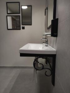 a white sink in a bathroom with mirrors at Cruzeto in Syvota