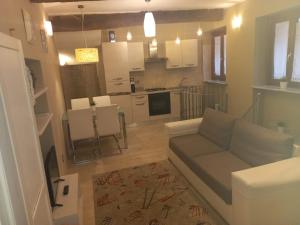 a living room with a couch and a kitchen at Antico Vicolo - Appartamento Giulia in Vercelli +22 photos