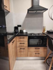 a kitchen with a black stove and wooden cabinets at Cruzeto in Syvota