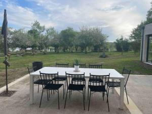 uma mesa branca e cadeiras com um campo ao fundo em Maison campagne/Lac, 8 personnes em Saint-Quentin-sur-Charente