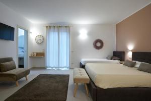 1 dormitorio con 2 camas, sofá y silla en B&B Il Girasole, en Capo dʼOrlando