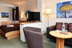 Habitación de hotel con cama y TV de pantalla plana. en Pension - Der Berghof, en Braunlage