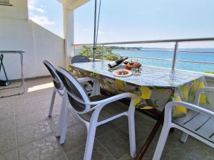 a table and chairs on a balcony with a view of the ocean at Villa Katarina in Petrcane