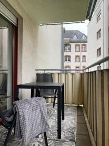 una mesa negra y sillas en el balcón en Quartier Süd, en Marburg an der Lahn