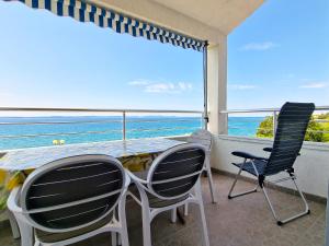 un tavolo e sedie su un balcone con vista sull'oceano di Villa Katarina a Petrcane