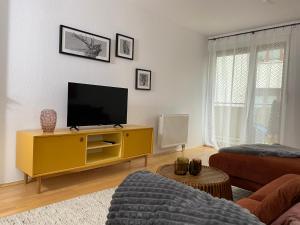 un salon avec une télévision sur une armoire jaune dans l'établissement Quartier Süd, à Marbourg