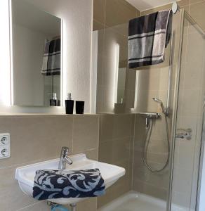 La salle de bains est pourvue d'un lavabo et d'une douche. dans l'établissement Quartier Süd, à Marbourg