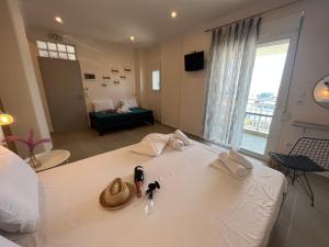 a room with a white bed with towels on it at House Kohili in Nea Vrasna