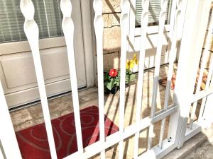 una porta con un cancello bianco con un vaso di fiori di Antica Pietra a Polignano a Mare