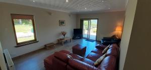 uma sala de estar com um sofá e uma televisão em Highland Haven, Glencoe em Ballachulish
