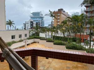馬蒂尼奧斯的住宿－Apto todo equipado em Caiobá há 50m do mar，阳台享有棕榈树城市的景致。