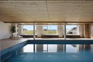 a large swimming pool in a building with a van at Loft mit Seeblick und Innenpool 