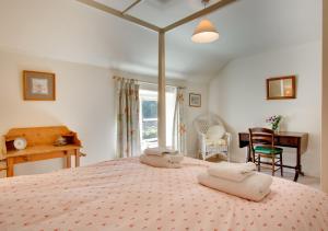 a bedroom with a large bed with two towels on it at Byre Cottage in Langham