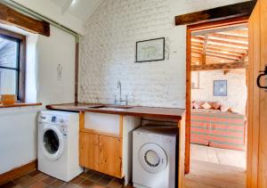 a kitchen with a washing machine and a sink at Byre Cottage in Langham
