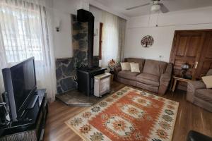 a living room with a couch and a fireplace at Fethiye Üzümlüde havuzlu müstakil tatil villası in Fethiye