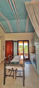 a dining room with a table and a kitchen at Attico Romantico vista mare alla Maddalena in La Maddalena