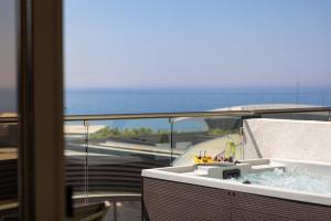 a bath tub on a balcony with a view of the ocean at Atlantica Bay - Adults Only in Limassol