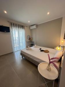 a bedroom with a large bed with two tables at House Kohili in Nea Vrasna