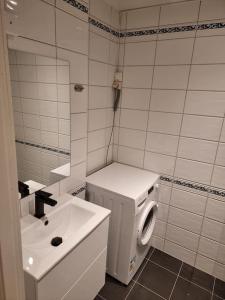 a white bathroom with a sink and a washing machine at Apartment nearby sentrum in Bergen