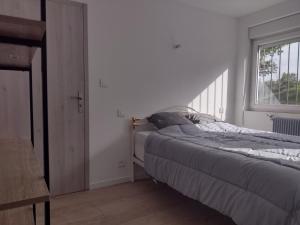 Schlafzimmer mit einem Bett und einem Fenster in der Unterkunft Gîtes BEL'M in La Bresse