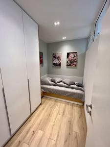 een slaapkamer met een bed in een kamer met een houten vloer bij Sofia Opera Apartment in Sofia