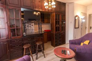 un salon avec une cuisine dotée d'armoires en bois dans l'établissement La casa de Bašta, à Bajina Bašta