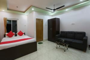 a bedroom with a bed and a couch and a table at OYO Flagship 67063 Roy Villa Resort in Baharampur