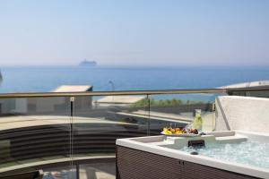 a bath tub on a balcony with a view of the ocean at Atlantica Bay - Adults Only in Limassol