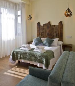 een slaapkamer met een groot bed met een houten hoofdeinde bij PENSION SOBRADO in Porta