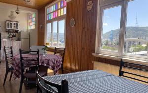 a dining room with two tables and two windows at Guest House Third Floor in Tbilisi City