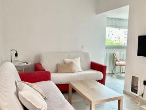 sala de estar con sofá rojo y blanco en APARTAMENTO GENOVEVA PLAYA - ValdelagranaCadizCom, en El Puerto de Santa María