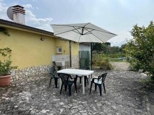 a white table and chairs with an umbrella at Mini House da Maria in Ortona