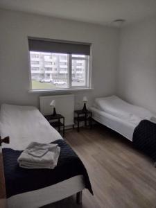 ein Schlafzimmer mit 2 Betten und ein Fenster mit einem Auto in der Unterkunft Guesthouse Maddy in Húsavík