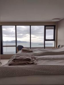 a bedroom with a bed with a view of the ocean at Guesthouse Maddy in Húsavík