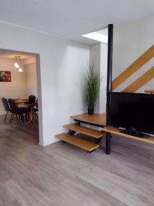 a living room with a tv and a table with chairs at Guesthouse Maddy in Húsavík