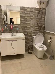 a bathroom with a toilet and a sink and a mirror at Luxe Suites Bahria Town Lahore in Lahore