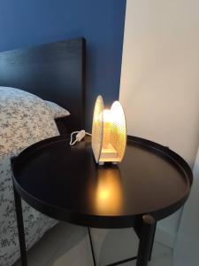 a lamp on a table next to a bed at Résidence Jehan Froissart in Valenciennes