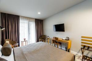 a hotel room with a bed and a television at Rasta Maidan Hotel in Tbilisi City