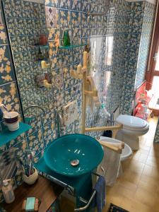 y baño con lavabo azul y aseo. en Little House, en Nettuno