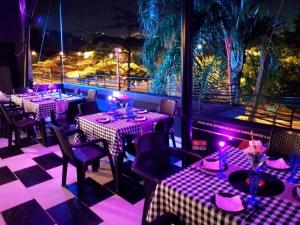 un restaurante con mesas y sillas con iluminación púrpura en Hotel Aqua lux en Medellín
