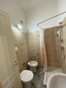 La salle de bains est pourvue de toilettes, d'un lavabo et d'une douche. dans l'établissement AFFITTACAMERE MINERVA, à Minervino di Lecce