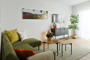 巴特諾因阿爾－阿爾韋勒的住宿－Quartier Oberhut，客厅配有绿色沙发和桌子