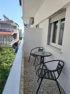 two chairs and a table on the side of a building at "BenLin" 3 in Paralia Katerinis