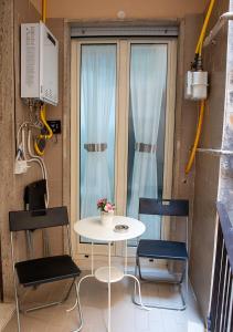 a small table and two chairs in a room with a window at zuroli suite in Naples